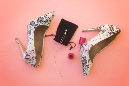 beautiful pump hight heeled and pink nail polish bottle and white pearl necklaceの写真素材