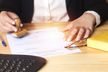 business woman, real estate agent at work and holding wooden stamp.