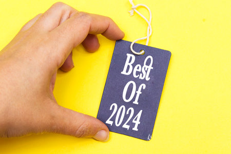 closeup hand holding tag with best of 2024, new year concept
