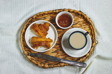 tray contains Morning breakfast in bed with coffee and apricot cookies, red rose flower and cup milk coffeeの写真素材