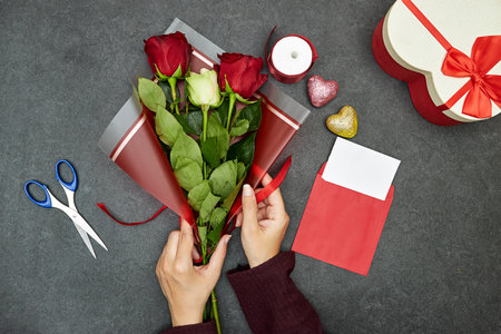 Cropped view of florist making flower bouquet as gift for valentine's day or birthday