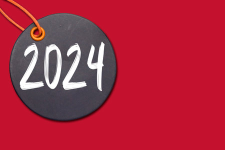 black cardboard Price tag or label with 2024 new year concept on red backgroundの写真素材