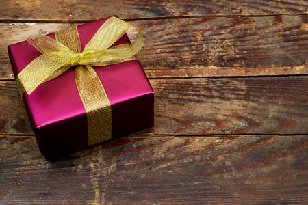 pink gift box with golden ribbon on wood table. flat layの写真素材