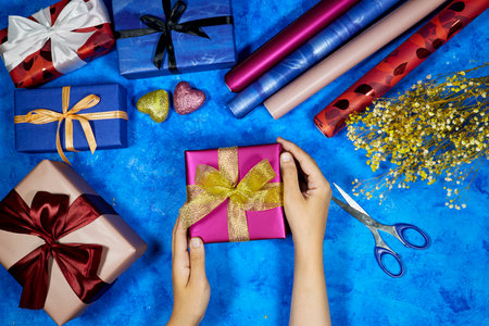 Woman wrapping Christmas gifts, overhead shot