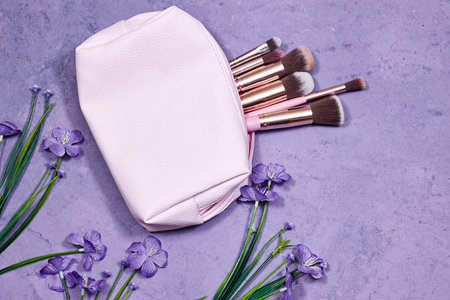 Beauty cosmetic makeup product layout. Fashion woman make up brushes with geranium flowers. Stylish...