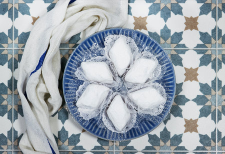 algerian traditional cookies named makrout is a almond paste forming diamond shape and covered with icing sugar on arabic tiles backgroundの写真素材