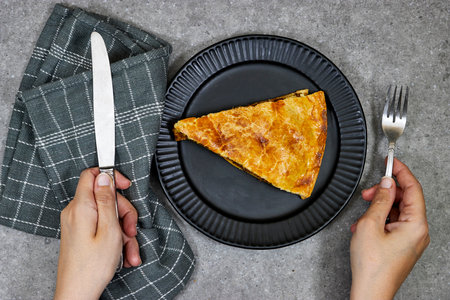 woman hands eating a homemade slice Meat Pie made from meat and cheese and egg