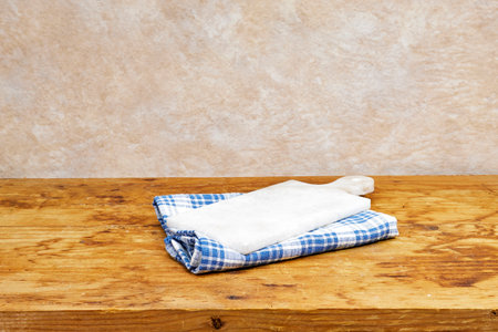 Empty wooden table with tablecloth and marble cutting board near grunge background