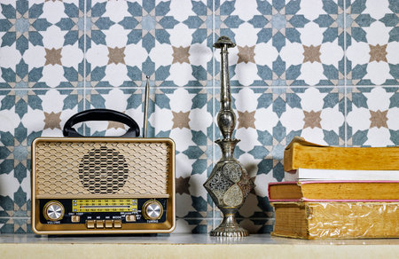 stylish retro radio player stands with books on white tableの写真素材
