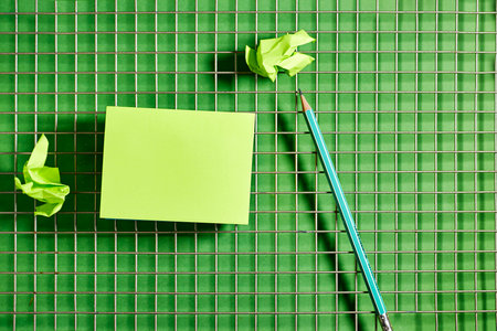 Notepads and pencils on a green background. View from above.