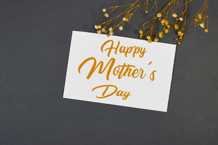 Mother's Day decorations concept. Top view photo of white invitation card with gypsophila flowers on gray backgroundの写真素材