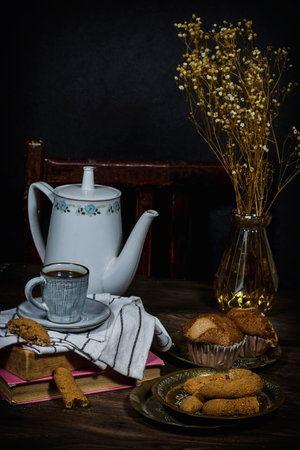 vintage photo of breakfast, gypsophila flowers vase with cookies and homemade madeleine, black coffeeの写真素材
