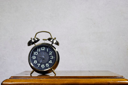 alarm o'clock showing 7 o'clock on wood table