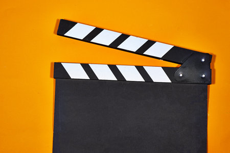 Movie clapper board isolated on orange background. Clipping path included.の写真素材