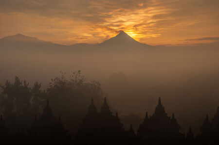 Merapi volcano on sunrise viewing from Borobudur Temple(silhouette scene)の写真素材
