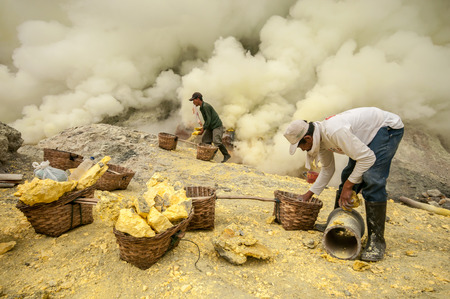 Kawah Ijen, Indonesia - April 24,2010 :  Workers extracting sulfur inside Ijen crater  in Ijen Volcano, Indonesia. He carries the load of around 60kg to the top of the rip and then 3km down.のeditorial素材