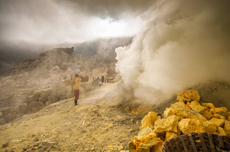 Kawah Ijen, Indonesia - April 24,2010 :  Worker carries sulfur inside Ijen crater  in Ijen Volcano, Indonesia. He carries the load of around 60kg to the top of the rip and then 3km down.のeditorial素材