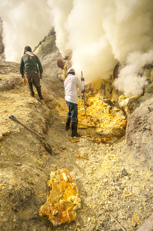 Kawah Ijen, Indonesia - April 24,2010 :  Workers extracting sulfur inside Ijen crater  in Ijen Volcano, Indonesia. He carries the load of around 60kg to the top of the rip and then 3km down.のeditorial素材