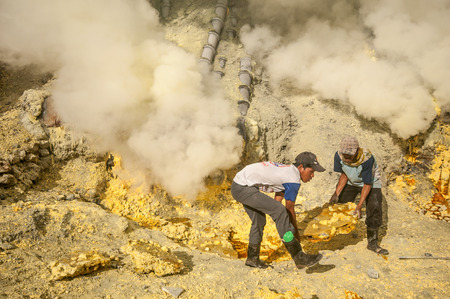 Kawah Ijen, Indonesia - April 24,2010 :  Workers extracting sulfur inside Ijen crater  in Ijen Volcano, Indonesia. He carries the load of around 60kg to the top of the rip and then 3km down.のeditorial素材
