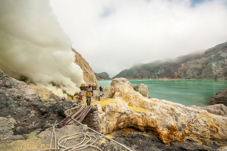 Kawah Ijen, Indonesia - April 24,2010 :  Worker carries sulfur inside Ijen crater  in Ijen Volcano, Indonesia. He carries the load of around 60kg to the top of the rip and then 3km down.のeditorial素材