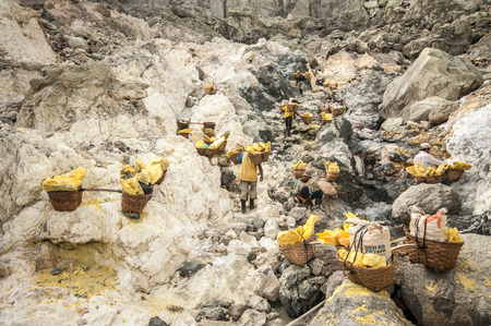 Kawah Ijen, Indonesia - April 24,2010 :  Worker carries sulfur inside Ijen crater  in Ijen Volcano, Indonesia. He carries the load of around 60kg to the top of the rip and then 3km down.のeditorial素材