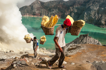 Kawah Ijen, Indonesia - April 24,2010 :  Worker carries sulfur inside Ijen crater  in Ijen Volcano, Indonesia. He carries the load of around 60kg to the top of the rip and then 3km down.のeditorial素材