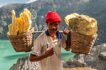 Kawah Ijen, Indonesia - April 24,2010 :  Worker carries sulfur inside Ijen crater  in Ijen Volcano, Indonesia. He carries the load of around 60kg to the top of the rip and then 3km down.のeditorial素材