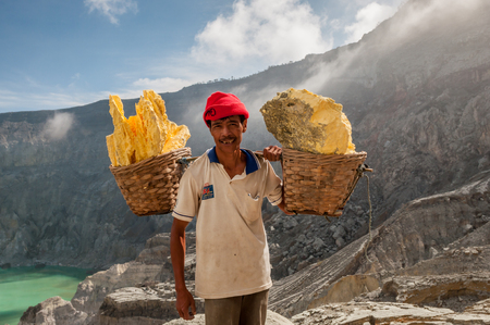 Kawah Ijen, Indonesia - April 24,2010 :  Worker carries sulfur inside Ijen crater  in Ijen Volcano, Indonesia. He carries the load of around 60kg to the top of the rip and then 3km down.のeditorial素材