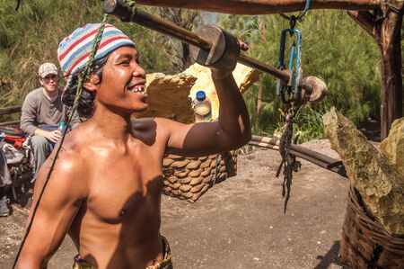 Kawah Ijen, Indonesia - April 24,2010 :  Worker weigh  sulfur inside Ijen crater  in Ijen Volcano, Indonesia. He carries the load of around 60kg to the top of the rip and then 3km down.のeditorial素材