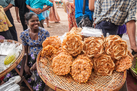 Thanlyin, Myanmar - March 14, 2011: The Myanmar vendor selling local snack at street market  in Thanlyin, Myanmar.のeditorial素材