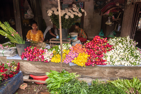 Thanlyin, Myanmar - March 14, 2011: The Myanmar vendor selling flowers at street market  in Thanlyin, Myanmar.のeditorial素材