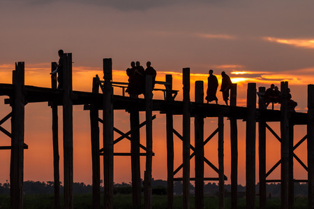 Mandalay,Myanmar-March 16,2011 : Unidentified Myanmar  People walking on U-Bein bridge in sunset in Mandalay, Myanmar. The U-Bein bridge is the longest teak bridge in the world, 1.2km lenght is spanning the Taungthaman Lake. It is 200 years old.のeditorial素材