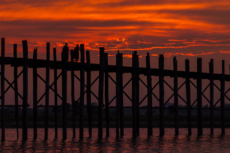 Mandalay,Myanmar-March 16,2011 : Unidentified Myanmar  People walking on U-Bein bridge in sunset in...