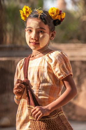 Bagan,Myanmar-March 18,2011: Unidentified Myanmar girl with thanaka on her smile face is happiness in Bagan, Myanmar.Thanaka is a yellowish-white cosmetic paste made from ground bark.のeditorial素材