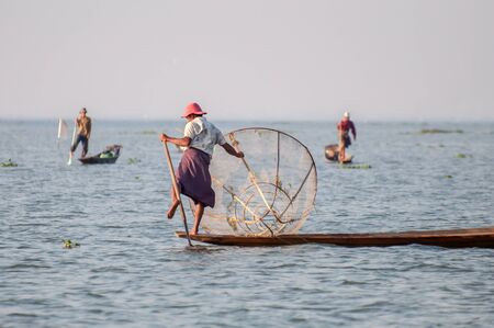 Inle, Myanmar - March 21,2011: Myanmar Inle  fisherman on boat catching fish by traditional net with possess the leg-rowing style in Inle of Shan state in Myanmar.Inle lake is 22km long and about 11km wide. The lake is at 1328 metres above sea level and  のeditorial素材