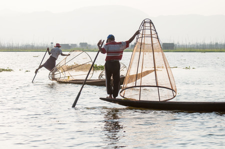 Inle, Myanmar - March 21,2011: Myanmar Inle  fisherman on boat catching fish by traditional net with possess the leg-rowing style in Inle of Shan state in Myanmar.Inle lake is 22km long and about 11km wide. The lake is at 1328 metres above sea level and  のeditorial素材