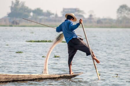 Inle, Myanmar - March 21,2011: Myanmar Inle  fisherman on boat catching fish by traditional net with possess the leg-rowing style in Inle of Shan state in Myanmar.Inle lake is 22km long and about 11km wide. The lake is at 1328 metres above sea level and  のeditorial素材