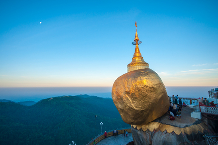 Kyaiktiyo,Myanmar-March 23,2011: Myanmar People praying and used gold leaf to pay homage and worship at Kyaikhtiyo pagoda on sunrise,That sits atop Mount Kyaiktiyo is one of the most sacred sites  in Kyaikhtiyo of Mon state in Myanmar.The pagoda is 1100kmのeditorial素材