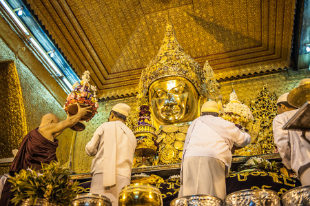 MandalayMyanmarMarch 172011 : Myanmar senior monk offering flower at Mahamuni Buddha image in Mandalay Myanmar .Mahamuni is the oldest Buddha statue in Myanmar It is also known as the Maha Myat Muni or Phaya Gyi.のeditorial素材