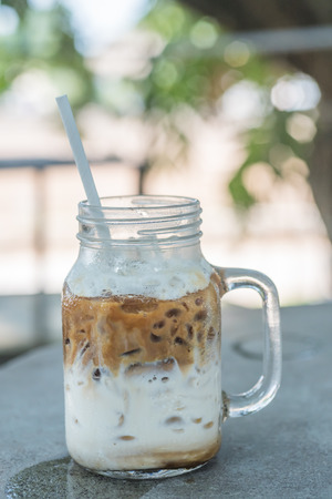 Iced coffee with milk in mason jars on the tableの写真素材