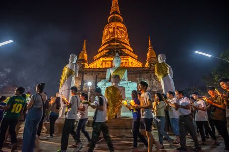 Ayutthaya ,Thailand - february 19, 2019 : Buddhists people walking (motion blur)  with lighted candles in hand around a ancient temple on Magha Puja day at Ayutthaya province of Thailand.のeditorial素材