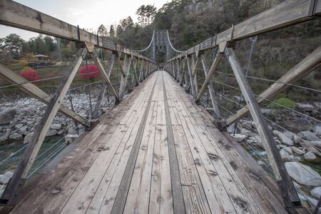 Nagiso,Nagano, Japan - April 20, 2019 : View of historical wooden Momosuke suspension bridge in Nagiso, on the Nakasendo Trail - Nagano Prefecture,  Japan.のeditorial素材
