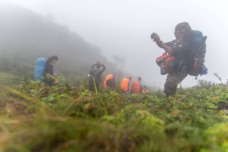 Phatthalung, Thailand-December  31, 2019: The trekkers trekking on foggy the mountains in jungle of...