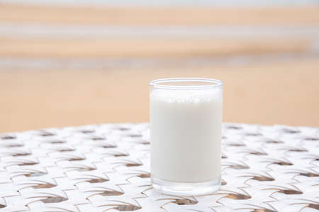 A glass of milk on white table next to the beach restaurantの写真素材