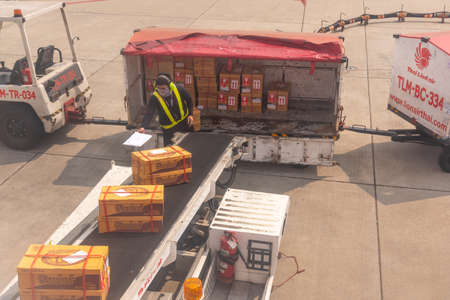 Bangkok, Thailand- January 24 2021 : Airline crew loads checked baggage into airplane cargo at Don Mueang airport (DMK) in Bangkok ,Thailand.のeditorial素材