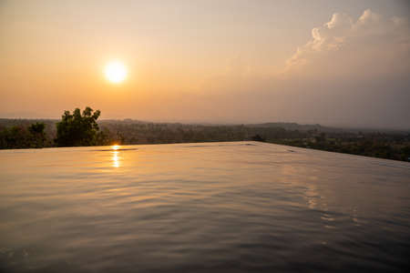 Sunset over the swimming pool with mountain view in Thailandの写真素材