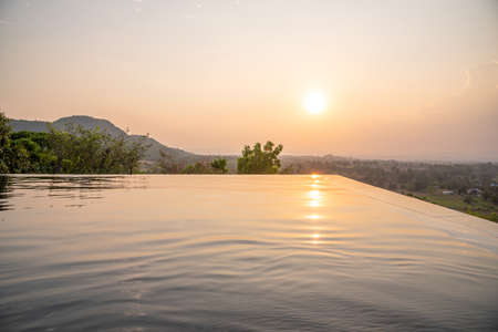 Sunset over the swimming pool with mountain view in Thailandの写真素材