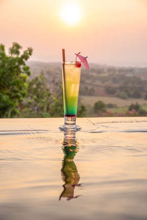 Cocktail near the swimming pool at sunset in Thailandの写真素材