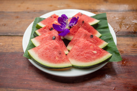 Tasty sliced watermelon on wooden table outdoorsの写真素材