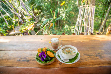 Homemade Pork rice soup and deep fried dough stick with ice tea,the local breakfast in southern of Thailandの写真素材
